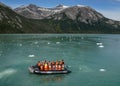 Zodiac boats from Ventus Australis expedition ship transfer tourists on the shore near Pia glacier in Patagonia