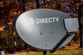 Tiffin, Iowa, USA - 10/2020: Directv satelite dish with fall leaves in background