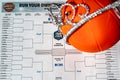 Tiffin, Iowa, USA - 3.2023 - NCAA Tournament Bracket with a miniature basketball and a Cinderella tiara.