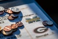 Tiffin, Iowa, USA - 12.2022 - Selective focus on 2021-2022 College Football Playoff Bracket with scattered coins.