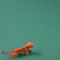 The tiger is sneaking up and ready to attack on a green background. Minimal animal scene