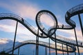 Tiger and Turtle, people as silhouettes on the stairs of the walkable roller coaster sculpture against a blue sky with pink clouds Royalty Free Stock Photo