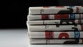 Stack of folded newspapers on a white surface with a dark background. Royalty Free Stock Photo
