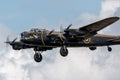 Tight shot of a Lancaster bomber from the side with bright cloudy sky in the background