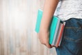 Tight shot of teenage midsection holding a colorful books