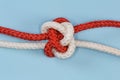 Tightened rope Diamond knot on a blue background close-up