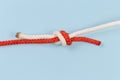 Tightened rope fisherman knot on a blue background