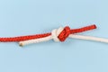 Tightened rope fisherman knot on a blue background Royalty Free Stock Photo
