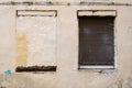 A blocked window and a window closed with a roller shutter in the old wall of the building Royalty Free Stock Photo