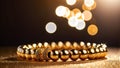 A tightly coiled necklace made of glittering golden beads lying on a dark surface Royalty Free Stock Photo