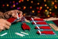 A tightly framed shot of someone working on crafts for the Christmas season. Only the craftsmanÃ¢â¬â¢s hands are visible in the shot