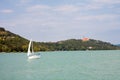 Tihany Peninsula with the Abbey and a sailboat viewed from a ship