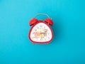 pretty red vintage retro style alarm clock with copy space on blue backgroun Royalty Free Stock Photo