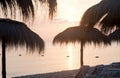 Tiki hut umbrellas, thatch. Sunrise view on beach in Tunisia. Travel