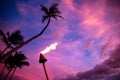 Tiki torch against tropical sunset