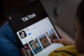 TikTok app seen on the screen of ipad which is in the hands of unrecognisable child. Concept. Stafford, United Kingdom, May 18,