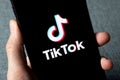 TikTok application icon on Apple iPhone 11 screen close-up.