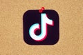 TikTok icon printed on paper and pinned on wooden background