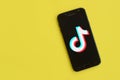 Tiktok logo on samsung smartphone screen on yellow background. TikTok is a popular video-sharing social networking service owned Royalty Free Stock Photo