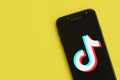 Tiktok logo on samsung smartphone screen on yellow background. TikTok is a popular video-sharing social networking service owned Royalty Free Stock Photo