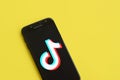 Tiktok logo on samsung smartphone screen on yellow background. TikTok is a popular video-sharing social networking service owned Royalty Free Stock Photo