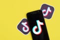 Tiktok logo on samsung smartphone screen on yellow background. TikTok is a popular video-sharing social networking service owned Royalty Free Stock Photo