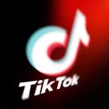 Tiktok logo on smartphone screen on black background. TikTok is a popular video-sharing social networking service owned Royalty Free Stock Photo