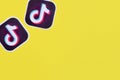 Tiktok paper logo on yellow background. TikTok is a popular video-sharing social networking service owned by ByteDance