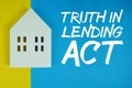 TILA Truth in Lending Act text with house models on blue background Royalty Free Stock Photo