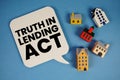TILA Truth in Lending Act text with house models on blue background Royalty Free Stock Photo