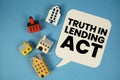 TILA Truth in Lending Act text with house models on blue background Royalty Free Stock Photo