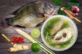 Tilapia and Boiled tilapia fish in clear bowl and Ingredients curry on wooden background Tom-yam-pla thai word, Piece slice fish