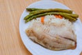 Tilapia sea fish with rice and green asparagus on a white thai. Healthy eating Royalty Free Stock Photo