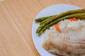 Tilapia sea fish with rice and green asparagus on a white thai. Healthy eating Royalty Free Stock Photo