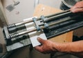 Tile cutter in the man`s hand. A builder is cutting white tiles for renovation maintenance work indoors Royalty Free Stock Photo