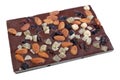 Tile of homemade chocolate with pieces of dry fruit and nuts isolated