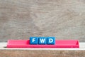 Tile letter on rack in word FWD Abbreviation of forward on wood background