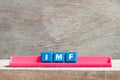 Tile letter on rack in word IMF abbreviation of International Monetary Fund on wood background