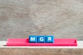 Tile letter on rack in word mgr abbreviation of manager on wood background Royalty Free Stock Photo