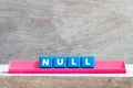 Tile letter on rack in word null on wood background