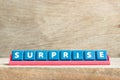 Tile letter on rack in word surprise on wood background