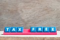 Tile letter on rack in word tax free on wood background