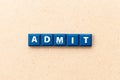 Tile letter in word admit on wood background Royalty Free Stock Photo