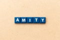 Tile letter in word amity on wood background