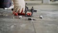 Tile Leveling Hand Tools Tile Fixing Tools Positioner Locator Leveler. A male construction worker installs large ceramic