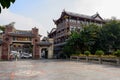 Tile-roofed buildings near gate of park in sunny afternoon