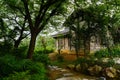 Tile-roofed timberwork building behind trees in cloudy spring af