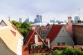 Tile roofs of old Tallinn between which green trees and bright flowers are visible Royalty Free Stock Photo