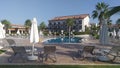 A tiled area near the pool with metal railings, surrounded by buildings with balconies and palm trees, is lined with plastic and f Royalty Free Stock Photo