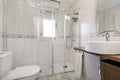 Tiled bathroom with white tiles, shower cabin with glass screens and circular porcelain sink with mirror on the wall Royalty Free Stock Photo